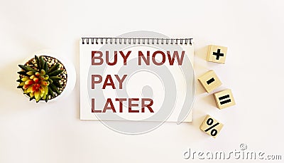 Text buy now pay later on notepad and white background. Cubes with zakami plus, minus, equals Stock Photo