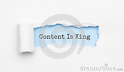 The text coNTENT IS KING appearing behind torn yellow paper Stock Photo