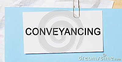 Text Conveyancing on a white card on a blue background. Business concept Stock Photo