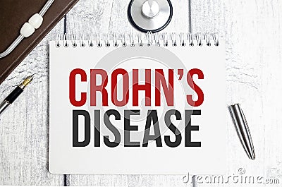 The text CROHN DISEASE on a notebook on a white table next to a stethoscope Stock Photo