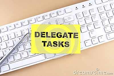 Text DELEGATE TASKS text on a sticky on keyboard, business concept Stock Photo