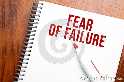 Text Fear of Failure written in notepad, Office wood table from above, concept image for blog title or header image. Aged vintage Stock Photo