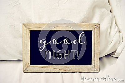 Text good night in a chalkboard on a bed Stock Photo