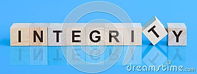 The text integrity is written on the cubes in black letters, the cubes are located on a blue glass surface Stock Photo