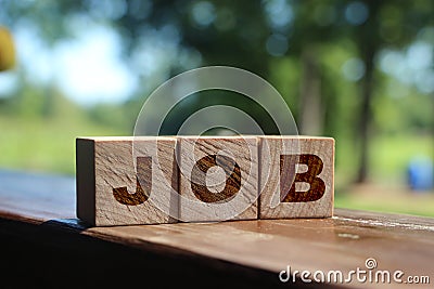 Text JOB on wooden cubes on table outdoors in nature. Freelance career business concept Stock Photo
