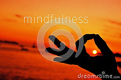 Text mindfulness and hand in gyan mudra at sunset Stock Photo