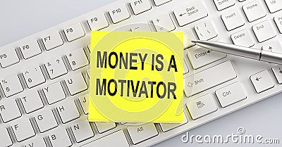 Text MONEY IS A MOTIVATOR on the keyboard on the white background Stock Photo