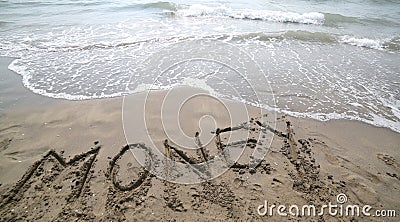 text MONEY on the sand and wave that is erasing the word symbol Stock Photo