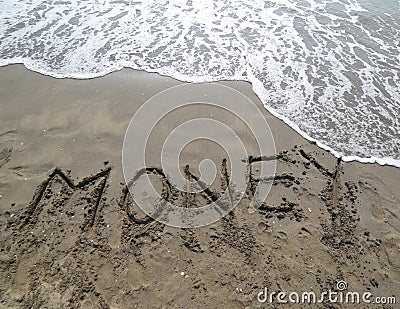 Text MONEY written on the sand and the wave that is erasing the Stock Photo