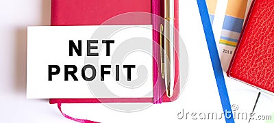 Text NET PROFIT on white card lying on notepad on office desk. Financial concept Stock Photo