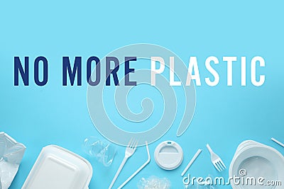 Text NO MORE PLASTIC and different disposable dishware on light blue background, flat lay Stock Photo