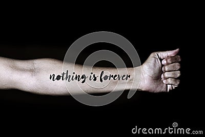 Text nothing is forever in a forearm Stock Photo