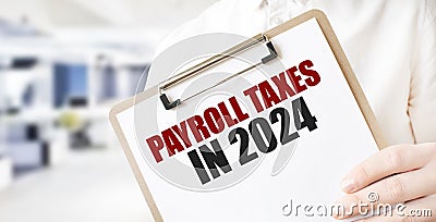 Text PAYROLL TAXES IN 2024 on white paper plate in businessman hands in office. Business concept Stock Photo