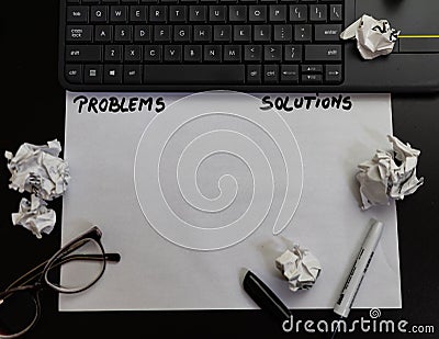 Text problems and solutions on paper..Different objects on black office desk. Modern black office desk table with laptop keyboard Editorial Stock Photo