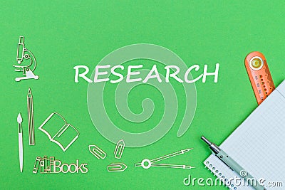 Text research, school supplies wooden miniatures, notebook with ruler, pen on green backboard Stock Photo