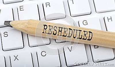 Text RESHEDULED on wooden pencil on white keyboard. Business concept Stock Photo