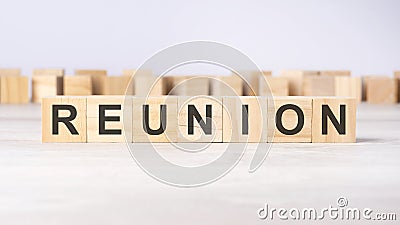 text REUNION on wooden cubes on bright grey background. square wood blocks. top view, flat Stock Photo
