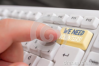 Text sign showing We Need Volunteers. Conceptual photo someone who does work without being paid for it White pc keyboard Stock Photo