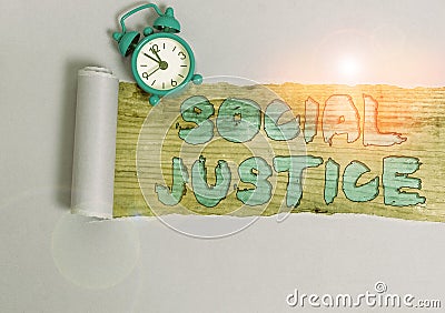 Text sign showing Social Justice. Conceptual photo Equal access to wealth and privileges within a society Alarm clock and torn Stock Photo