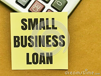 Text SMALL BUSINESS LOAN written on yellow paper note on calculator. Stock Photo