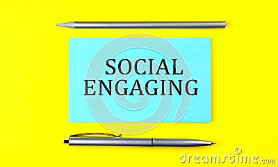 Text SOCIAL ENGAGING on the blue sticker on the yellow background Stock Photo