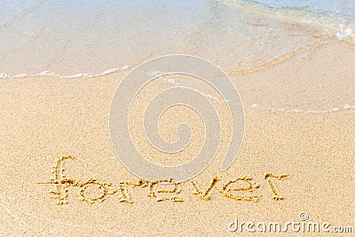 Text on a sunny beach. The word Forever written by hand in the sand, washed away by the sea wave. The concept of irony Stock Photo