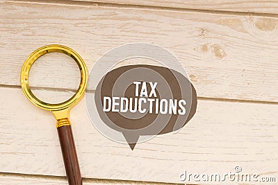 Text Tax Deductions on notepad with calculator, clips, pen on financial report. Financial and business concept photo Stock Photo