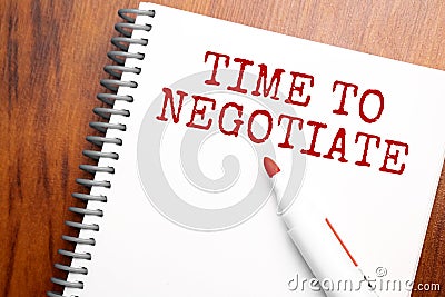 Text Time to negotiate written in notepad, Office wood table from above, concept image for blog title or header image. Aged Stock Photo
