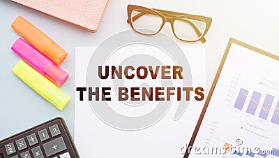 The text - UNCOVER THE BENEFITS on office desk with calculator, markers, glasses and financial charts Stock Photo