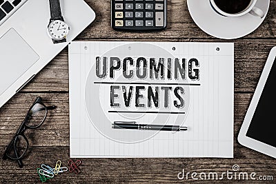 Text Upcoming Events written in notepad, Office desk with comput Stock Photo