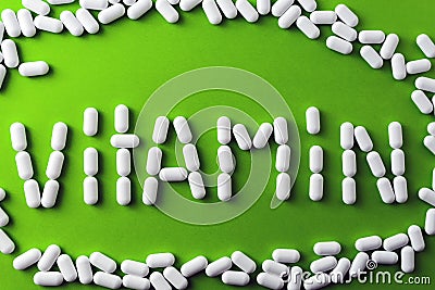 text - vitamins - of white pills, tablets on a green background, around pilule. Stock Photo