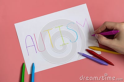 Text word autism on paper sheet written by colorful letter, on blue background. Stock Photo
