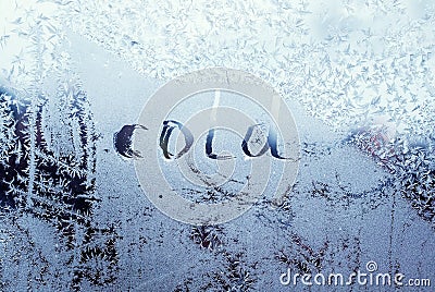 Text word cold on frosty glass covered with white frost crystals on window on winter cold clear morning Stock Photo