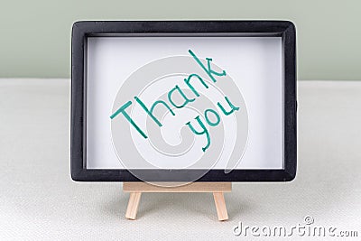 Text word THANK YOU, black frame, on white table. Stock Photo