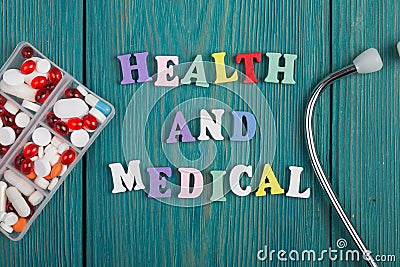 Text & x22;Health and medical& x22; of colored wooden letters, stethoscope and pills Stock Photo