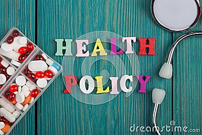 Text & x22;Health policy& x22; of colored wooden letters, stethoscope and pills Stock Photo