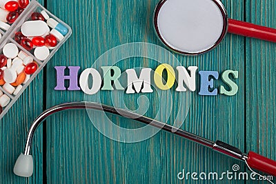 Text & x22;Hormones& x22; of colored wooden letters, stethoscope and pills Stock Photo