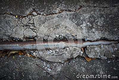 The old cement floor is cracked with steel pipes Stock Photo