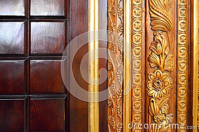 Texture of a beautiful carved wooden lacquered two-tone surface with patterns of squares, plant twigs and flowers. The background. Stock Photo