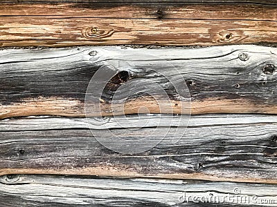 Texture of a black gray old wood wall made of logs, a fence of horizontal worn-out burnt, rotten boards with cracks and knots Stock Photo