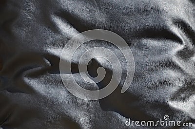 Texture of black leather or dermantin with folds, used as material for women`s and men`s bags, suitcases, pillows for office sofa Stock Photo