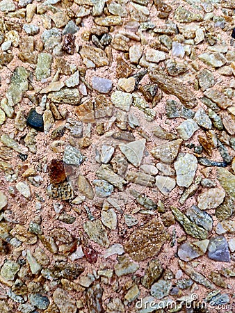 Texture. The concrete surface is pink with colored pebbles of various shapes Stock Photo