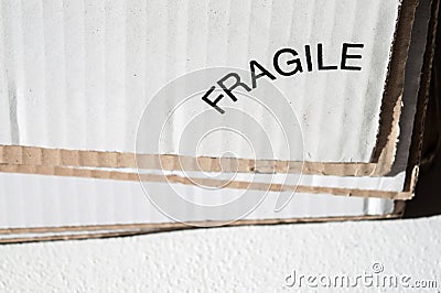 Texture of layered white and brown cardboard side. Folded cardboard boxes with printed label fragile. Wavy paper texture on Stock Photo