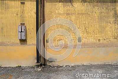 Texture of old yellow vintage wall of industrial factory with rusted iron pole Stock Photo