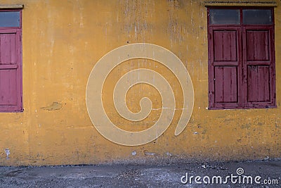 Texture of old yellow vintage wall of industrial factory with wooden windows Stock Photo