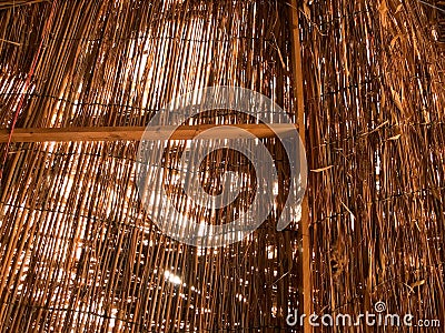 Texture of an orange dry straw shimmered in the sun roof of a thatched old bungalow. Natural decorative background Stock Photo