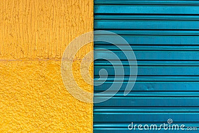 Texture pattern of cyan iron door of closed store and yellow wal Stock Photo
