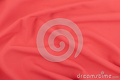 Texture of the red coral matt fabric with folds. Closeup of rippled red silk fabric in rose form Stock Photo