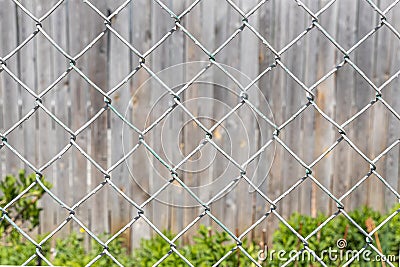 Texture of Rhombic cells of a white metal lattice is in the sunny day in the summer park on the gray wood background Stock Photo