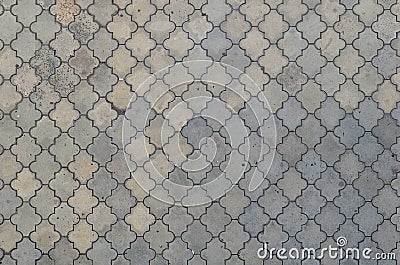 The texture of a rhythmic mosaic made of concrete tiles. Background image of a large area of old and damaged gray tile Stock Photo